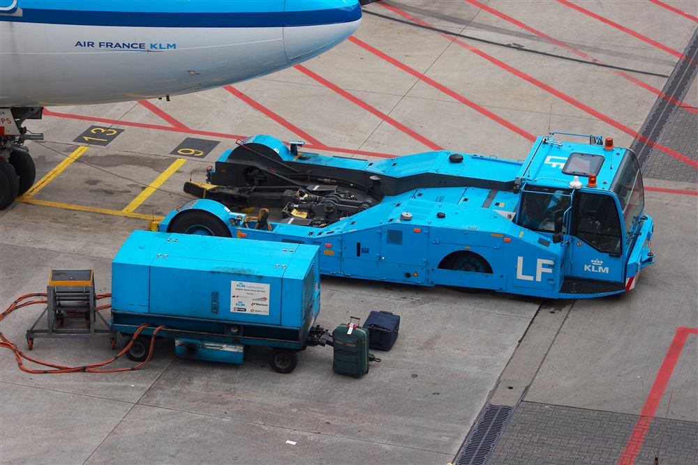 Ground power and pushback equipment positioned at an aircraft gate.