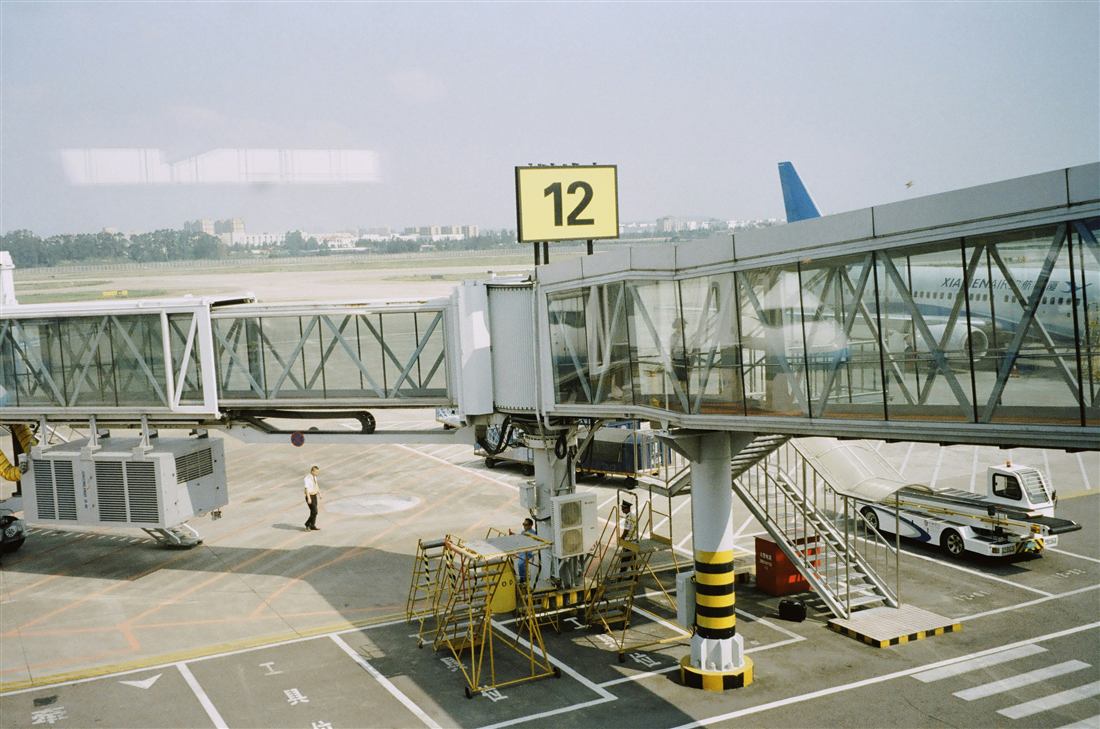 Airport tarmac and terminal apron under daylight operations.